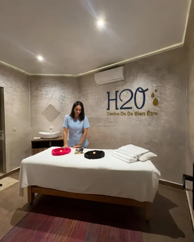 Thérapeute en tunique bleue installant la table de massage d’une cabine H2O Spa à Casablanca