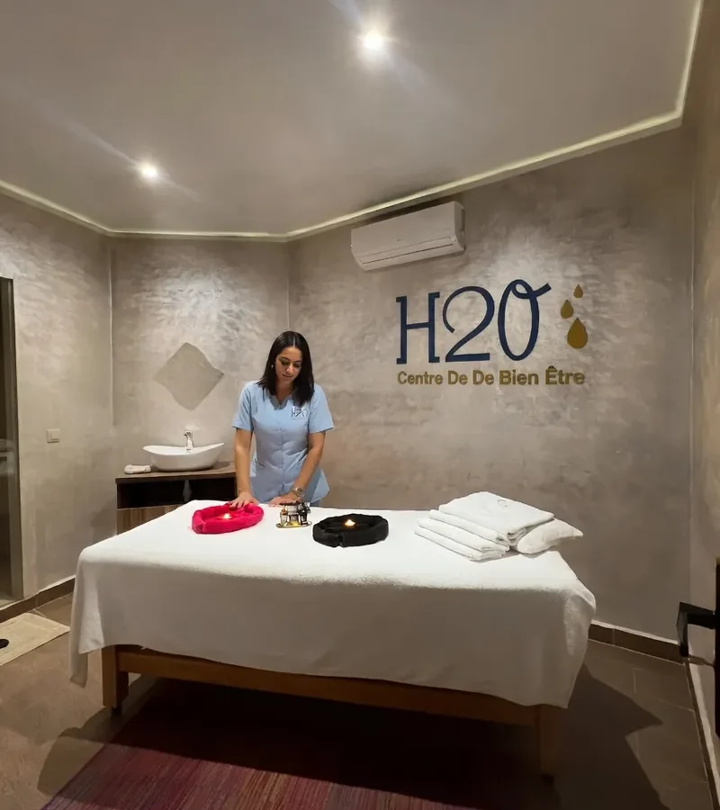 Thérapeute en tunique bleue installant la table de massage d’une cabine H2O Spa à Casablanca
